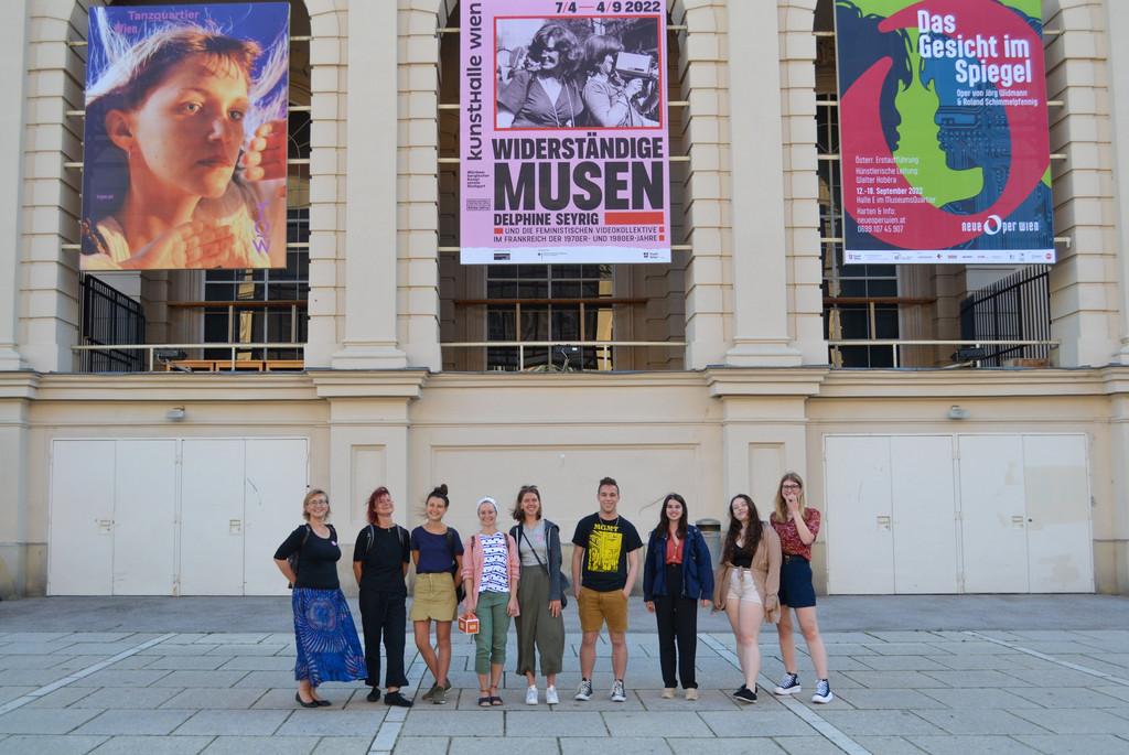 Teilnehmer vor einem Gebäude mit Filmplakaten an der Fassade